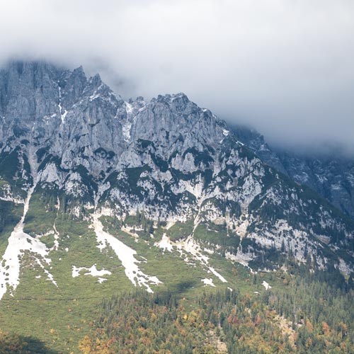 Blick auf eine Bergkuppe, die von Nebelwolken umhüllt ist